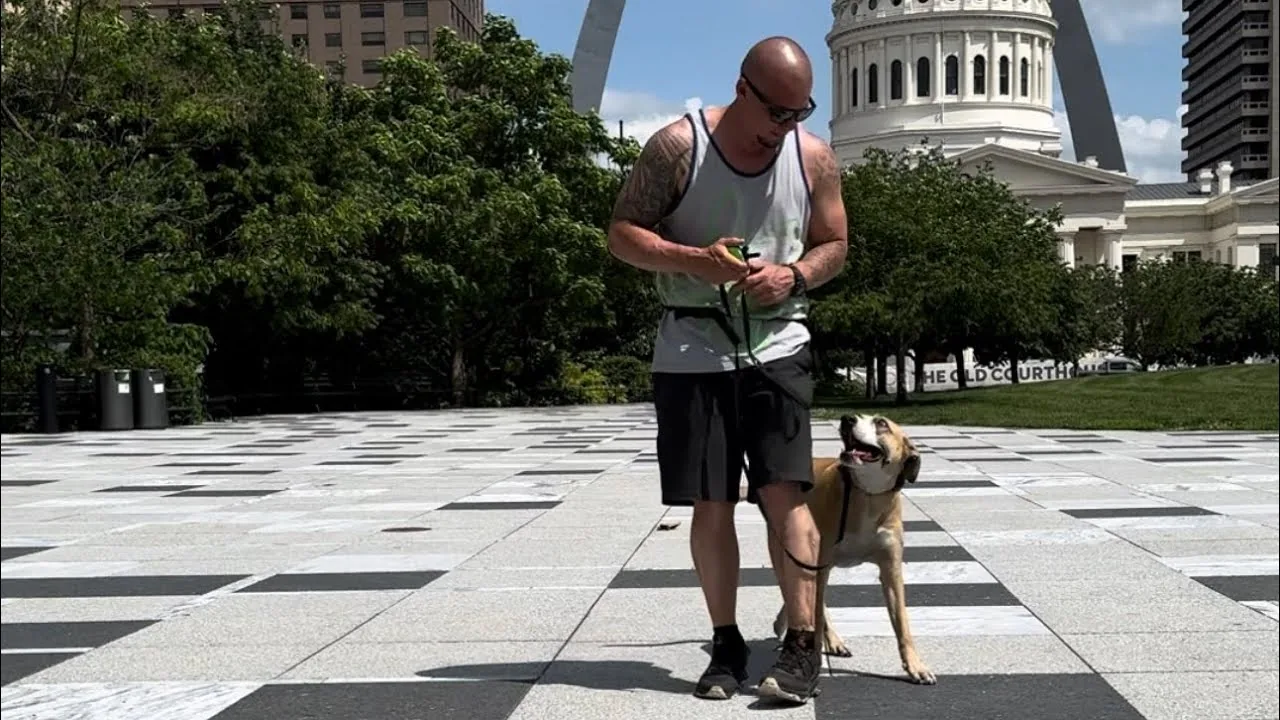 Aaron working Rey on a plaza in downtown St. Louis with the Arch behind